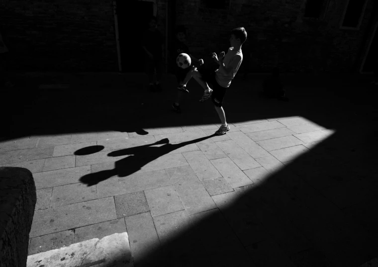 a man with a tennis racket in the shadows