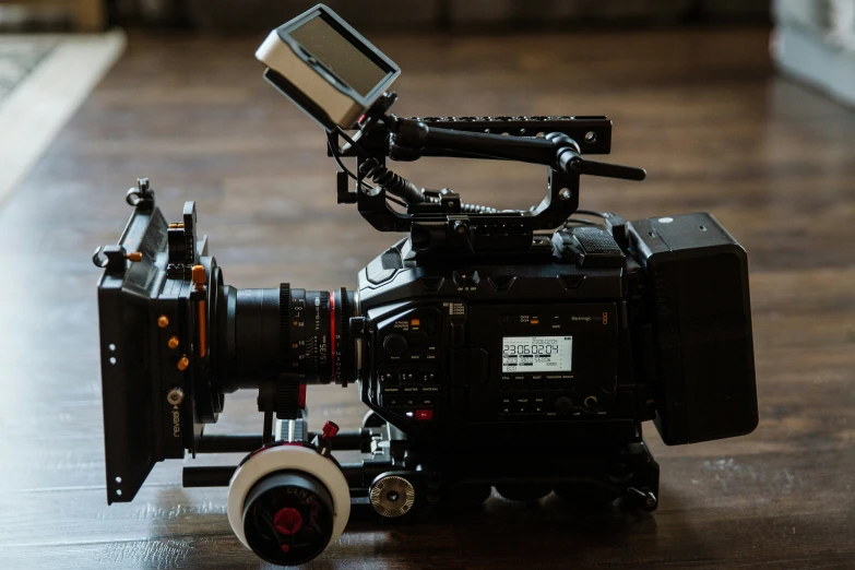 a close up of a black and red camera on a wooden table