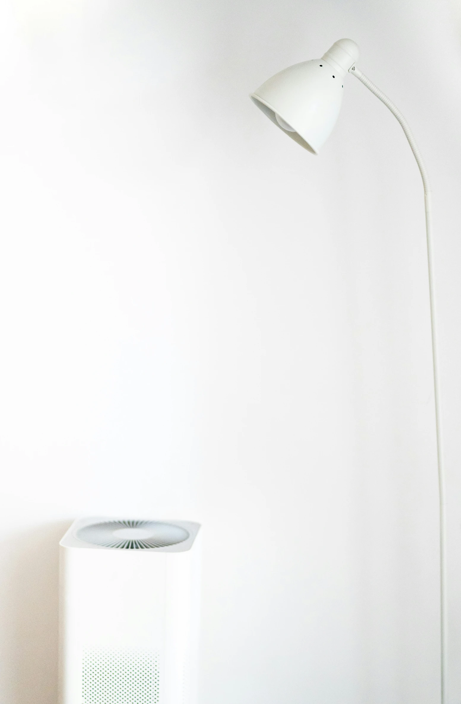 a lamp that is next to a white vase