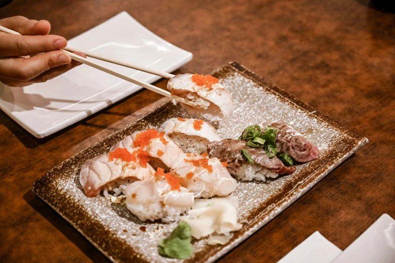 chop sticks holding chopsticks over food on a platter