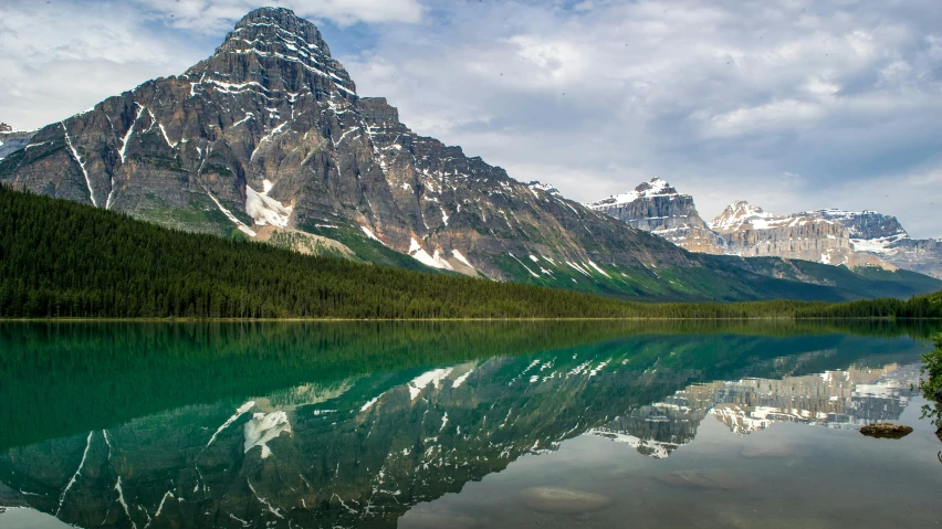 mountain reflected in still water near alpine lake