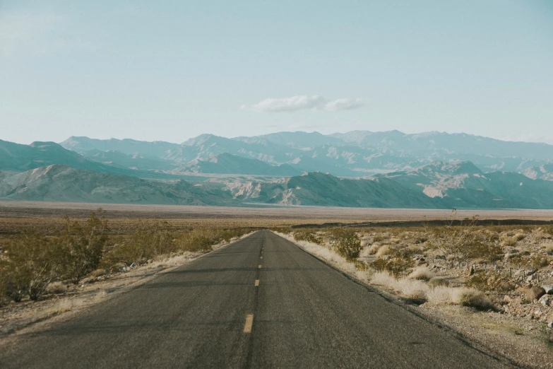 a lone motorcycle is parked on the empty road