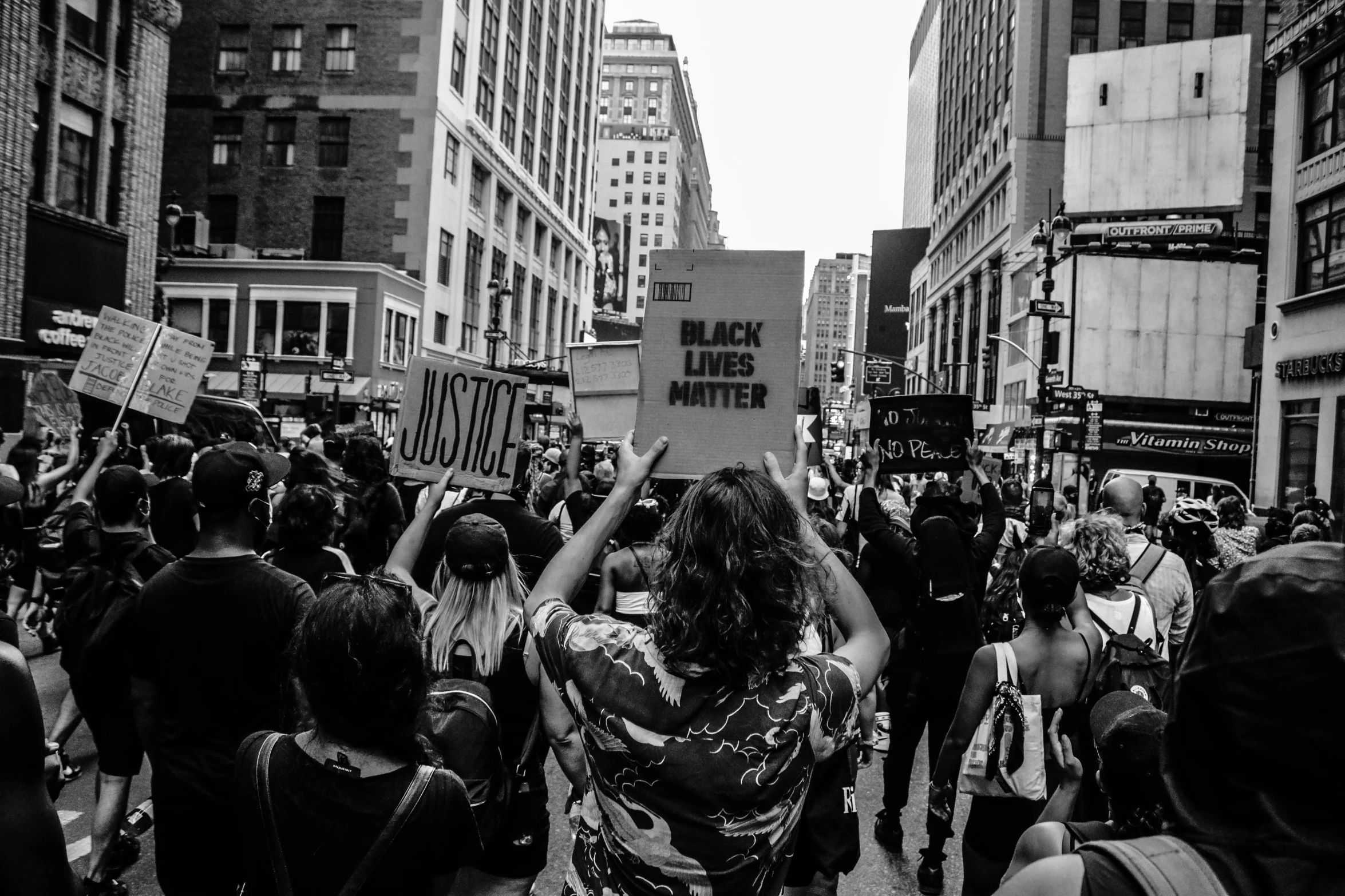 a crowd gathers around one another holding signs