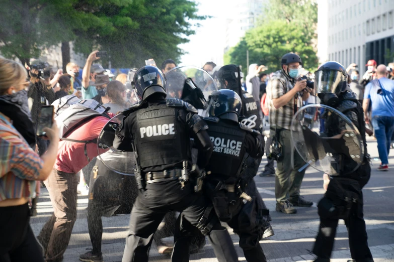 policemen detent protesters from the police and give them instructions