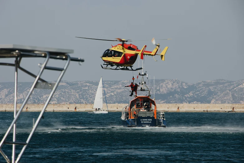 a helicopter is flying low to the ground over a boat