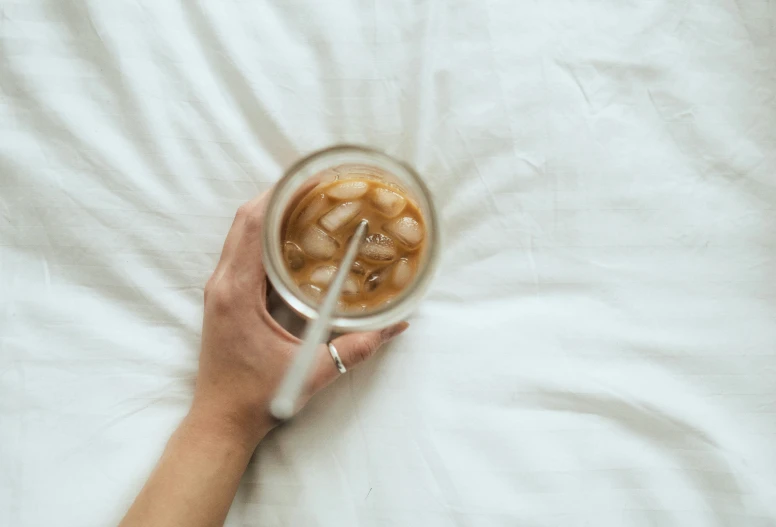 someone holding a cup of  chocolate with caramel slices