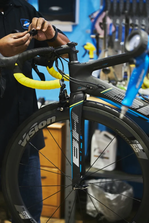 man looking at an item on a bike while fixing it