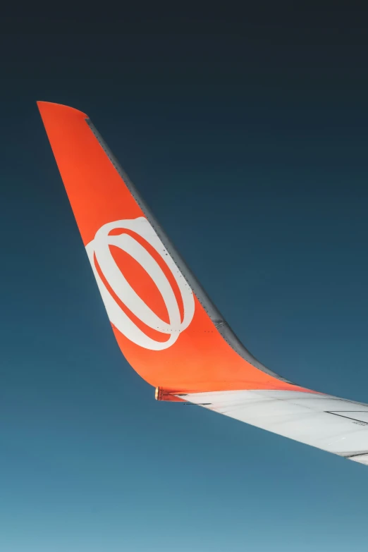 an orange and white airplane wing is shown in the air