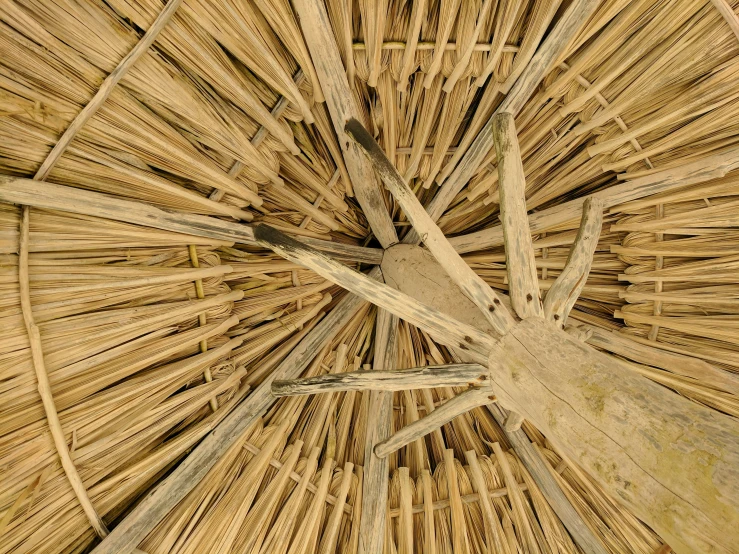 an umbrella made from woven sticks with wooden handle