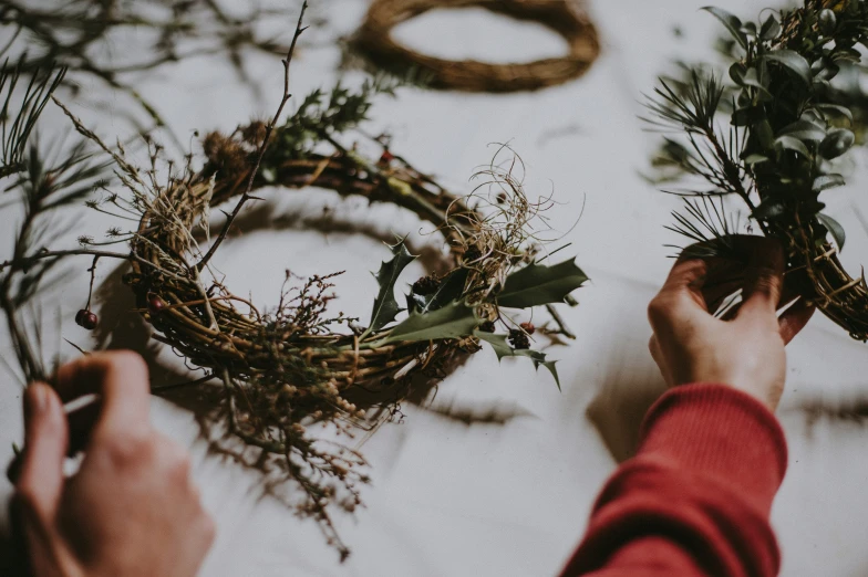 a man arranging wreaths on the table to decorate