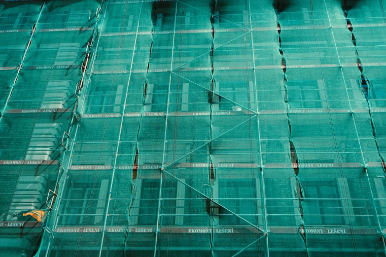 two people standing on a scaffolding outside a building