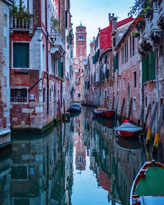 some boats on a narrow waterway next to a brick building