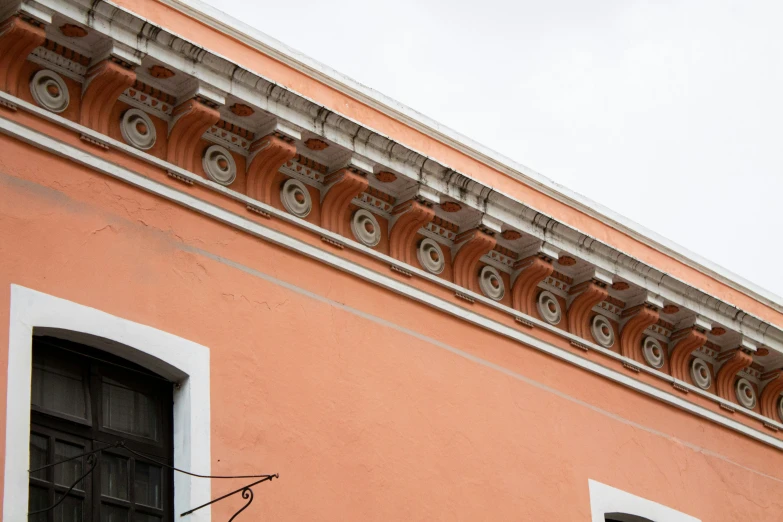 a tall pink building with ornate ornaments and doorways