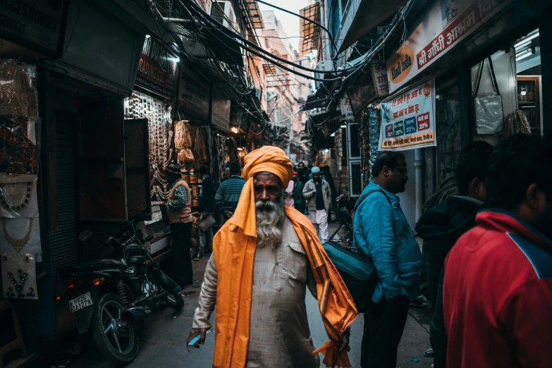 a man in yellow robes is walking on a crowded street