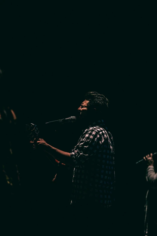 a man that is standing with his guitar in his hand