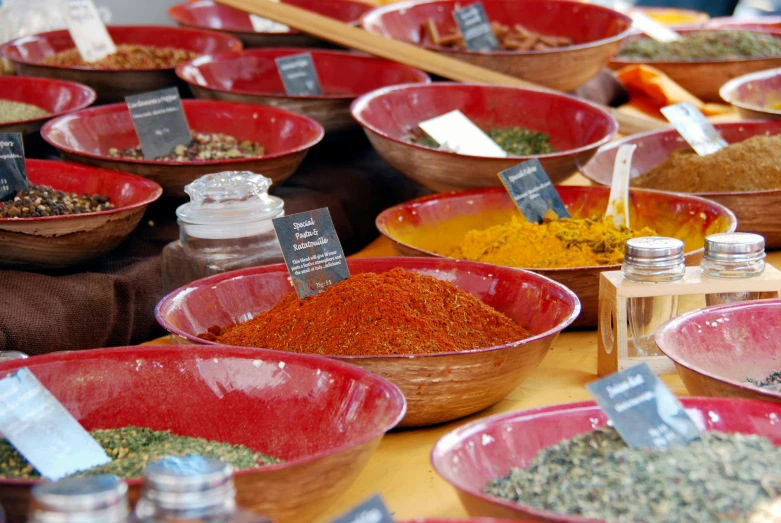 a table with many bowls with different kinds of spices