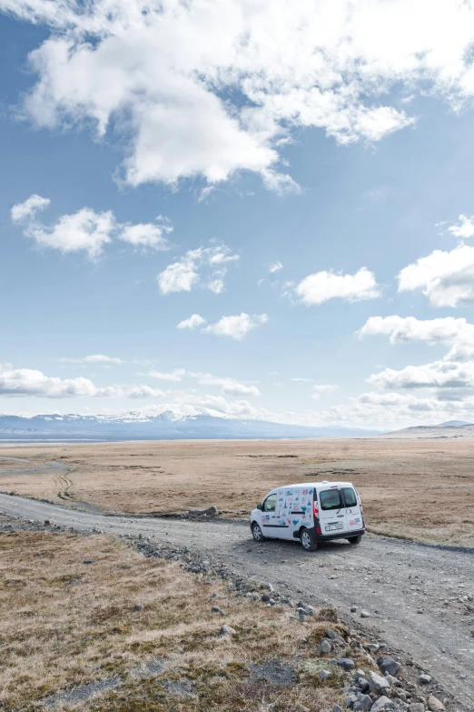 a van is parked in a field and it's not far from the mountains