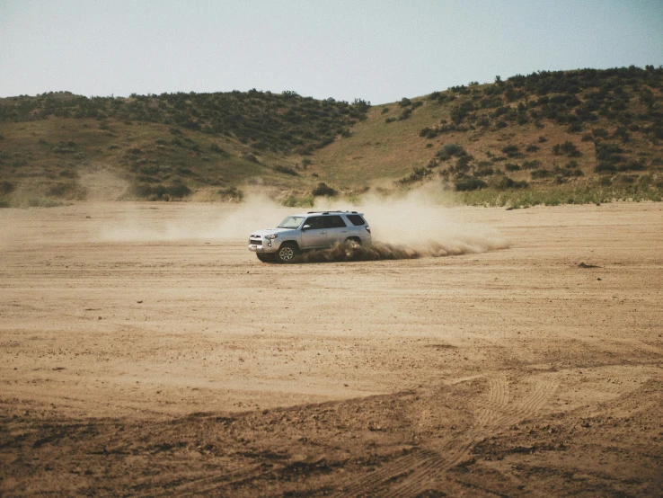 a jeep driving through an open desert road