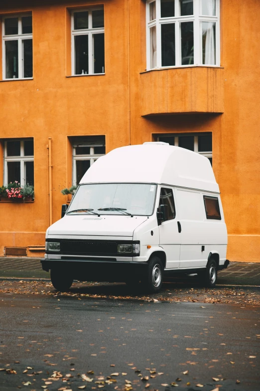 a white van parked in front of a large building