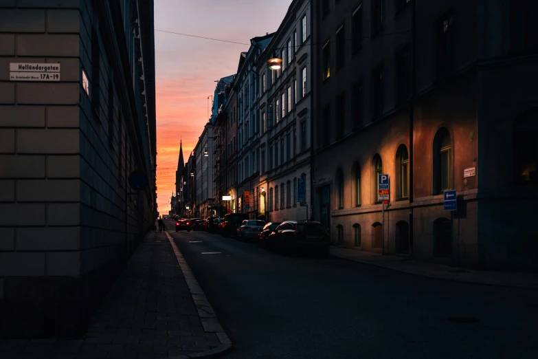 cars parked along the street as the sun rises