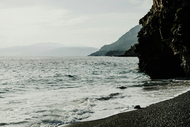 the ocean and mountains are near a beach