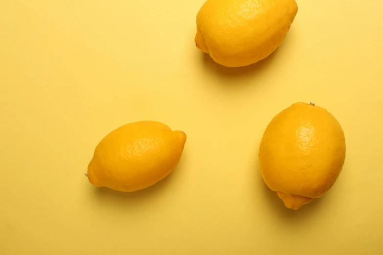 three ripe lemons laying on the ground