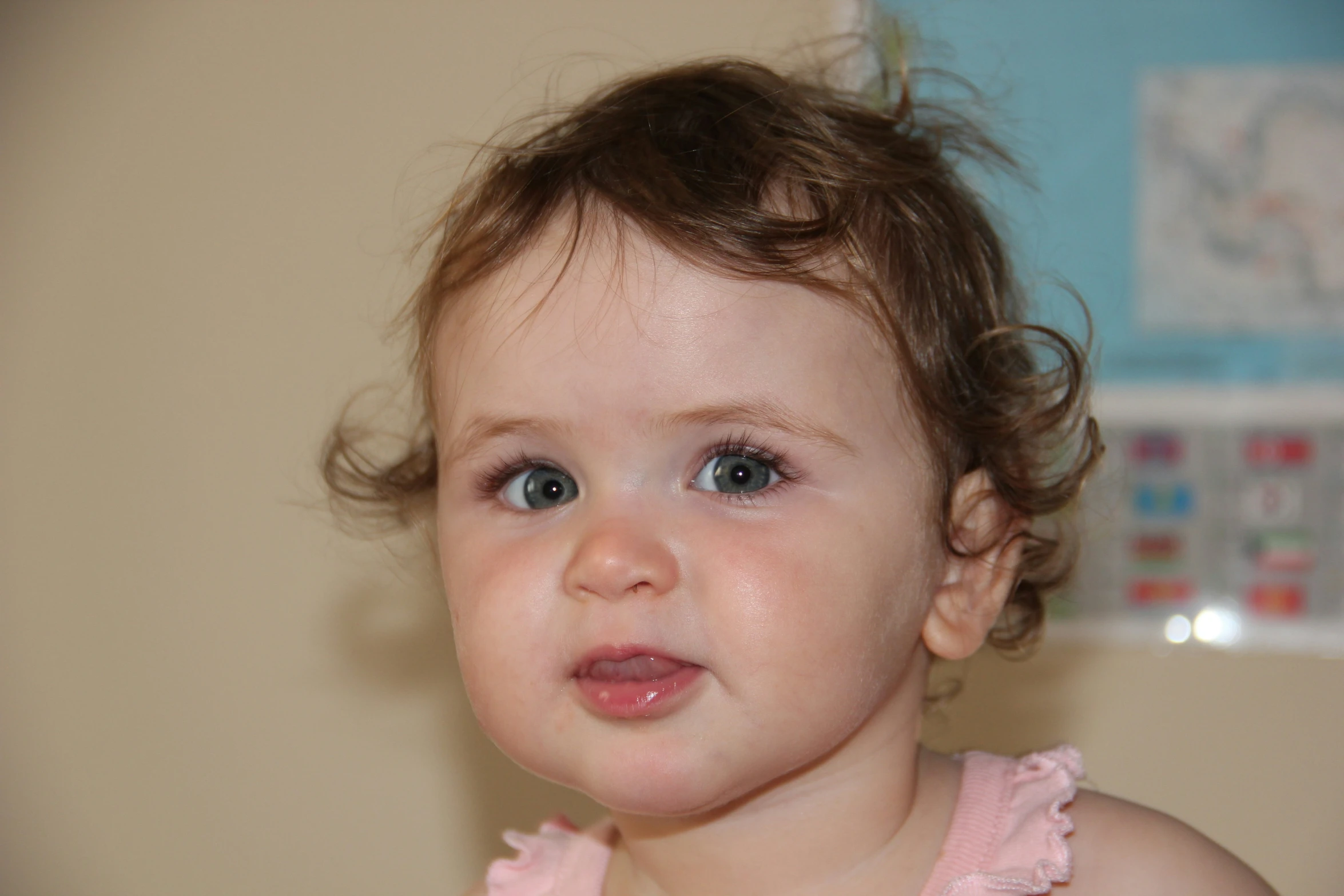 a baby with blue eyes and hair is wearing pink dress