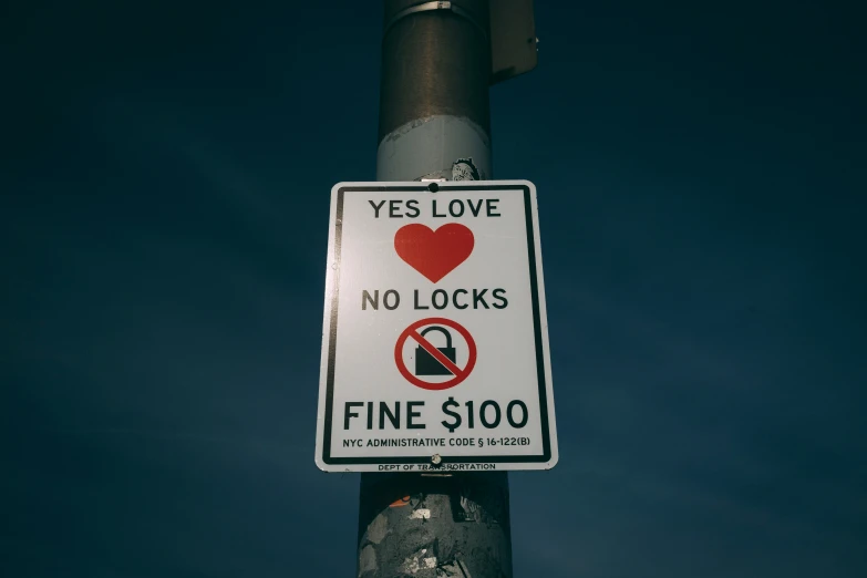 a no locks sign is on a street pole