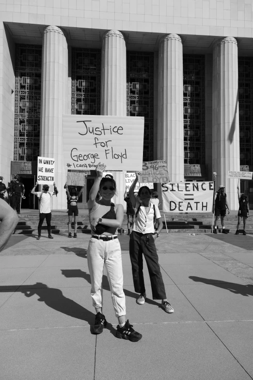 black and white pograph of people protesting outside large building