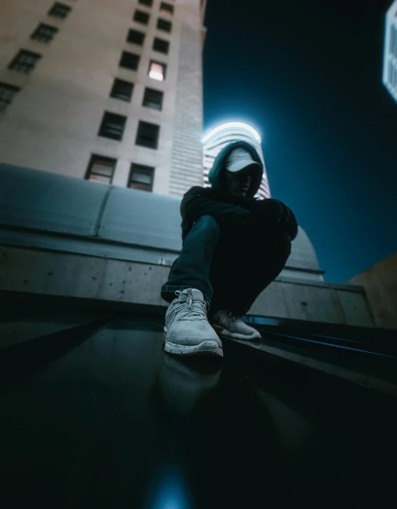 a person sitting on the ground wearing white sneakers