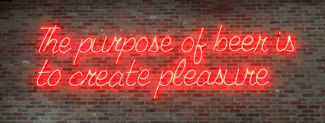 a red neon sign is against a brick wall