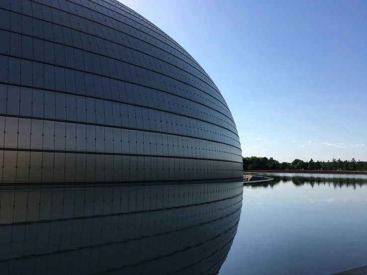 a large building by the water with water reflection