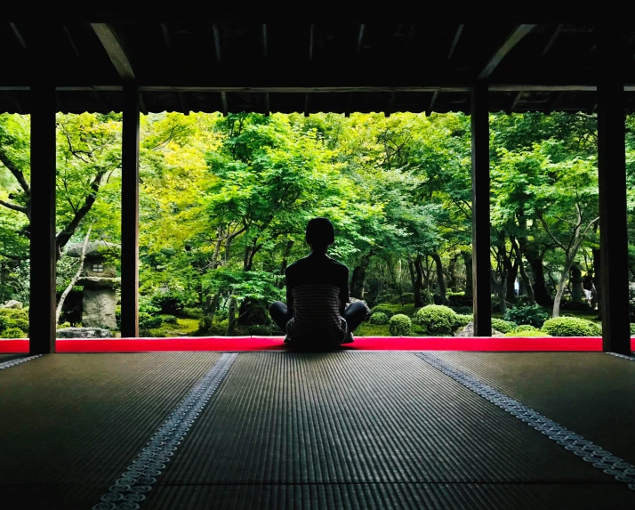 a person sits alone on an oriental covered area