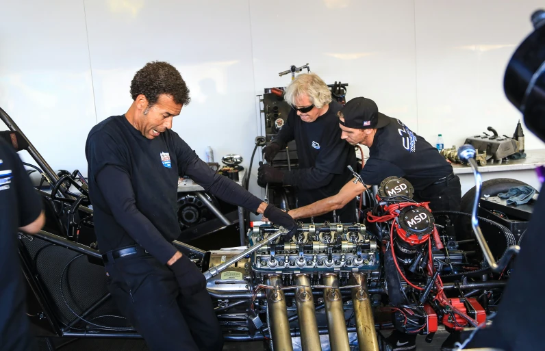 a group of men working on a motorcycle