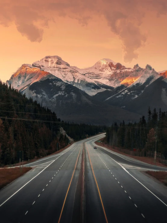 an empty road with a mountain in the background