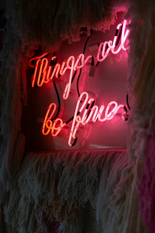 a pink neon sign with words hanging on it