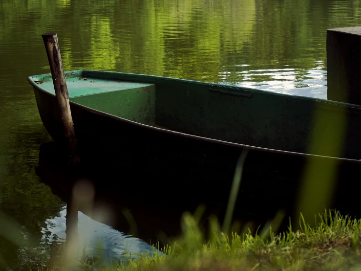 a green boat with the end in the water