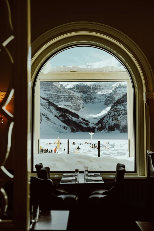 the mountains are covered with snow, seen through an open window