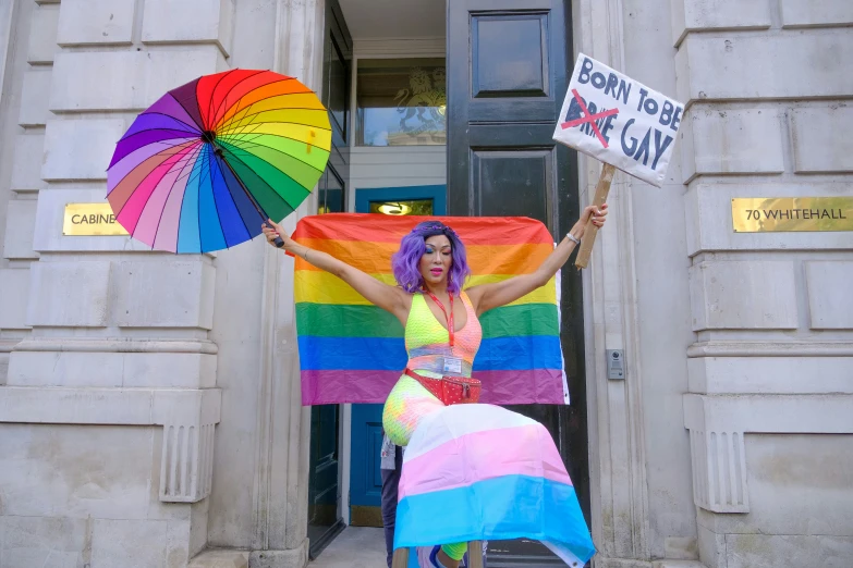 the woman is holding up two rainbow umbrellas