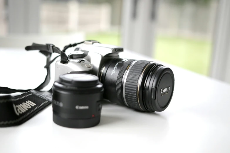 a camera sitting on top of a table next to a cup