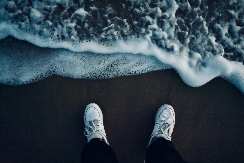 man standing near beach, with feet on shore