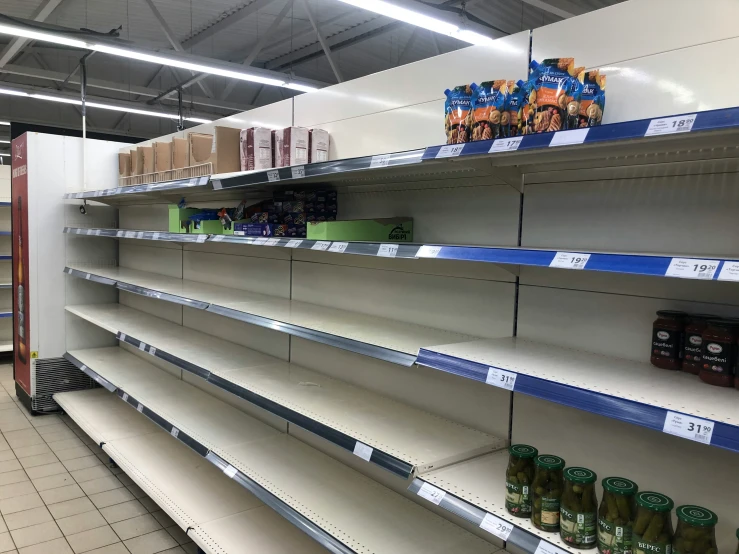 two rows of empty shelves in a grocery store