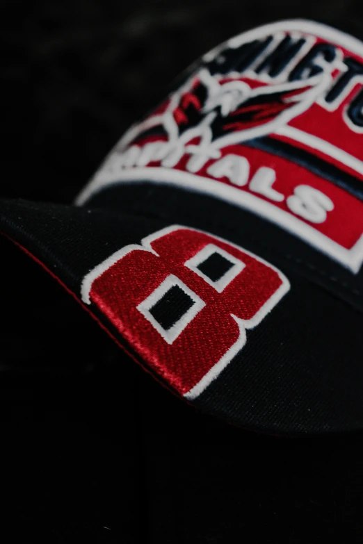 red and black baseball cap with red and white logos on it