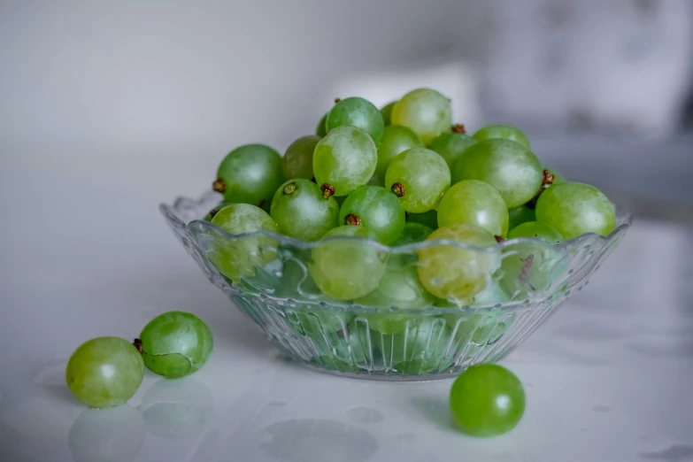 a glass bowl filled with green gs