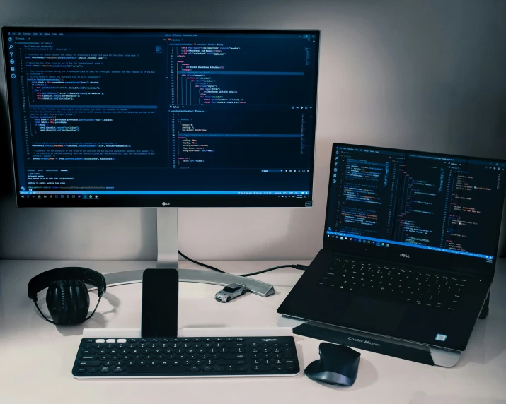 two computer screens sitting next to each other on top of a white desk