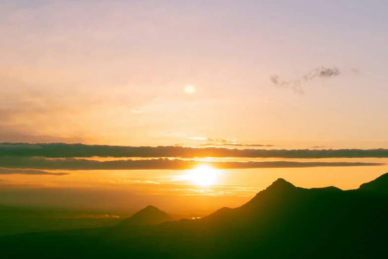 a view of mountains and the sky at sunset