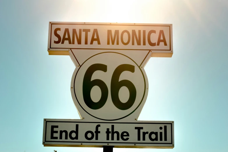 a santa monica sign on top of a pole in front of a blue sky