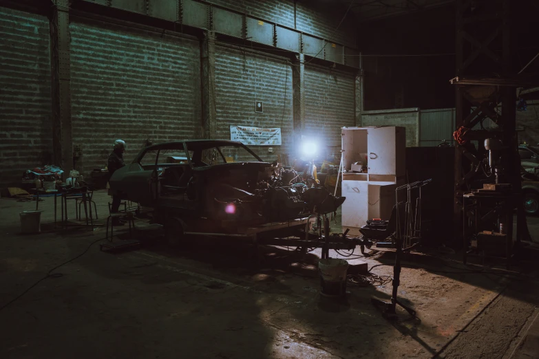 a car in a dark garage with lights shining on the front of it