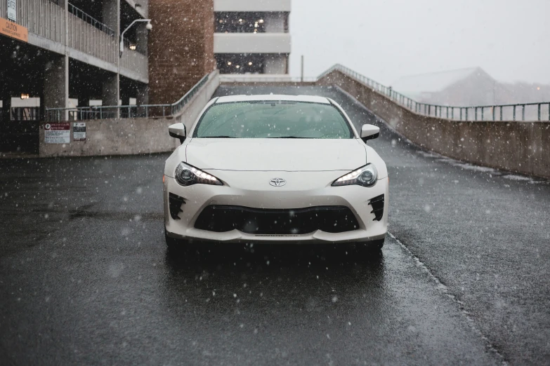 a white car is parked near the curb during a heavy snowstorm
