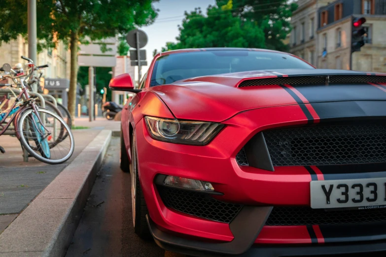 an image of a red mustang car parked on the side of the street